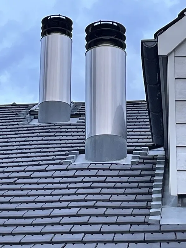 Double sortie de conduit de fumée en inox en toiture_Onex